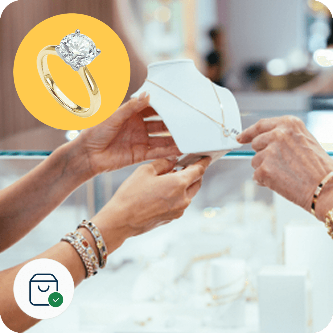 Hands examining a necklace on a display stand in a jewelry store; inset shows a gold ring with a diamond.
