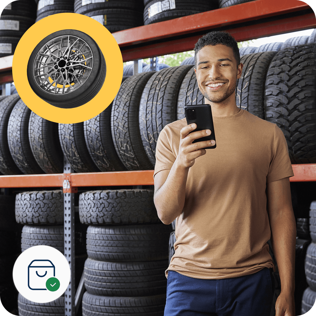Man smiling at phone in tire store, shelves filled with tires. Overlay shows a wheel and icons for shopping and confirmation.